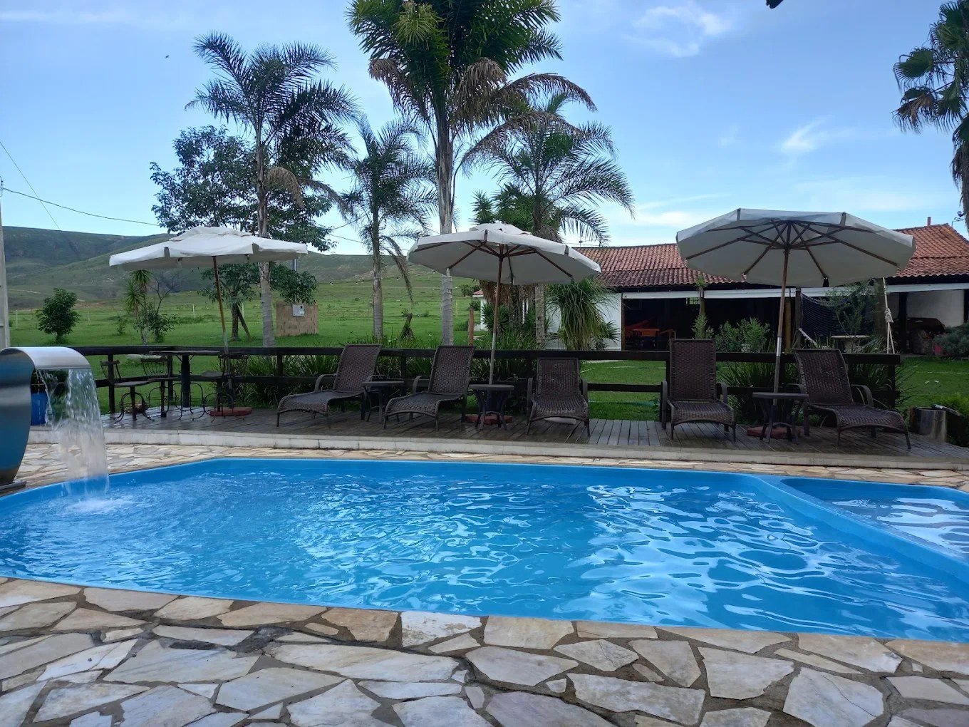Piscina com cascata e a serra ao fundo